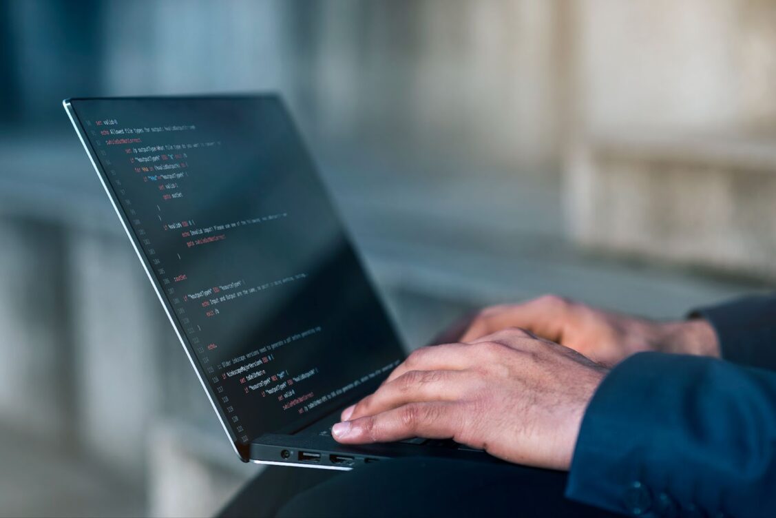 Man working on laptop with code